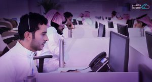 اشخاص يرتدون الزي السعودي ويعملون في مكاتب متجاورة